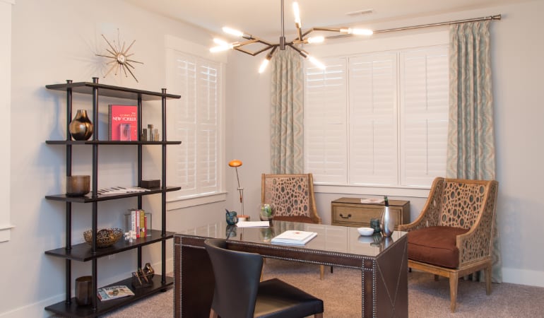 Picking the right window treatments can result in an increase in natural light. New York home office with plantation shutters.